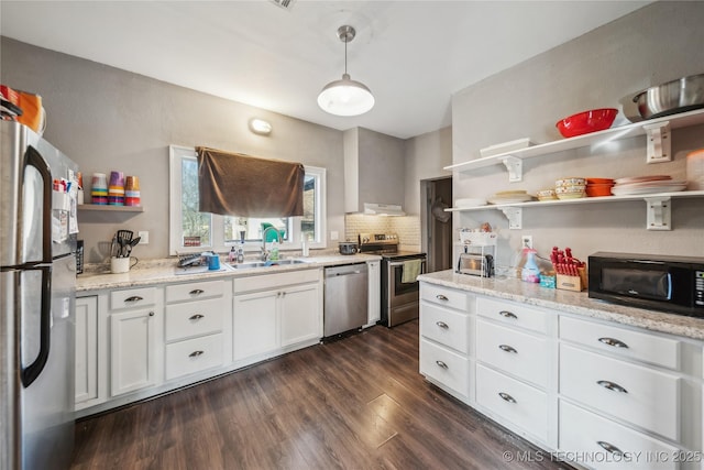 kitchen featuring pendant lighting, sink, dark wood-type flooring, appliances with stainless steel finishes, and white cabinets