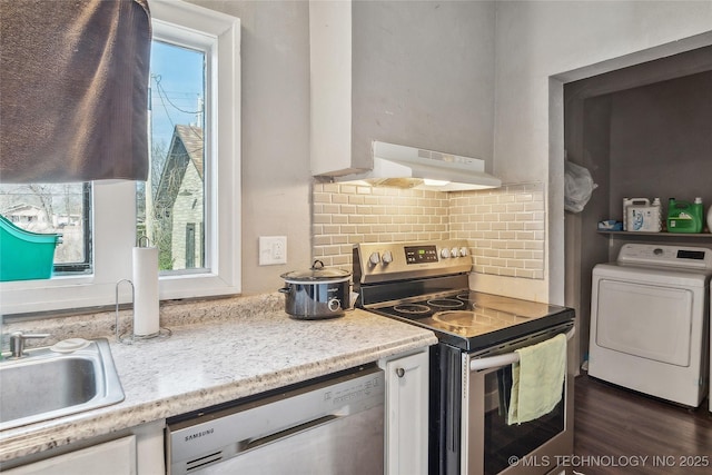 kitchen featuring appliances with stainless steel finishes, washer / dryer, sink, and a wealth of natural light