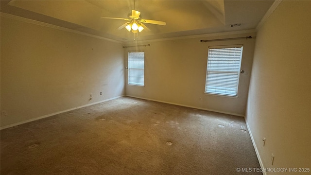 spare room featuring light carpet, a tray ceiling, ornamental molding, and ceiling fan