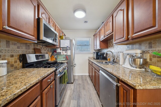 kitchen featuring stainless steel appliances, crown molding, sink, and backsplash