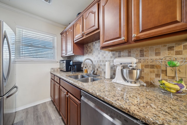 kitchen with sink, stainless steel appliances, tasteful backsplash, ornamental molding, and light stone countertops