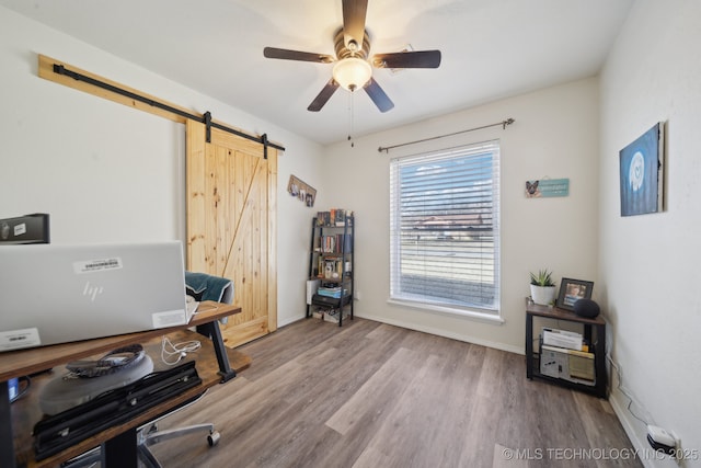 office space featuring a barn door, hardwood / wood-style floors, and ceiling fan