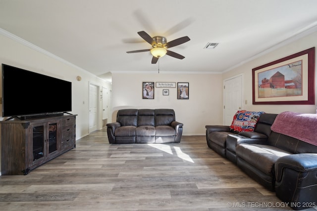 living room featuring crown molding, ceiling fan, and light wood-type flooring