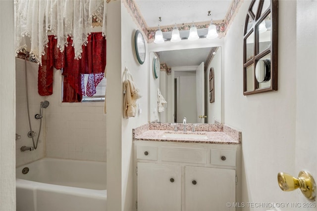 bathroom with tiled shower / bath and vanity