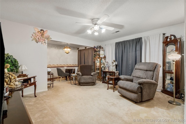 sitting room featuring ceiling fan, carpet floors, and a textured ceiling