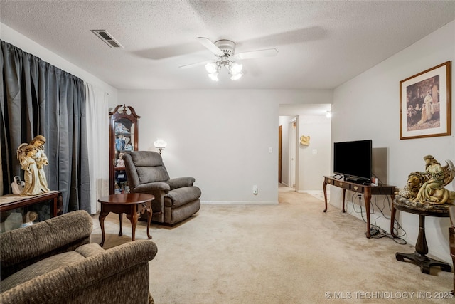 living room with ceiling fan, light carpet, and a textured ceiling