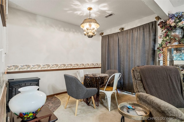 carpeted dining room with a chandelier