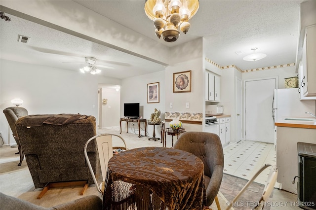 dining space featuring ceiling fan and a textured ceiling