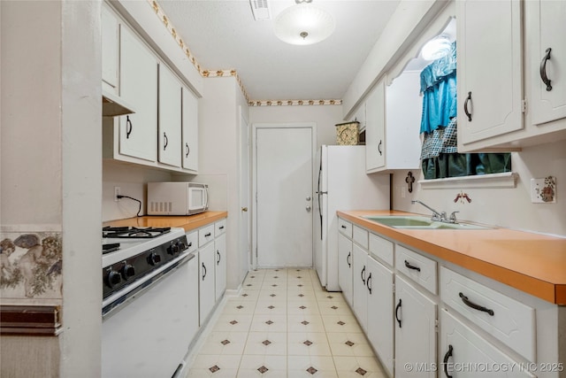 kitchen with white cabinetry, sink, and white appliances