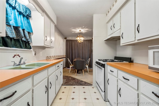 kitchen featuring sink, white appliances, a textured ceiling, and white cabinets