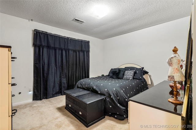 bedroom with light carpet and a textured ceiling