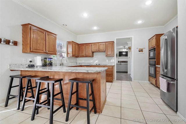 kitchen featuring light tile patterned flooring, a breakfast bar, crown molding, kitchen peninsula, and black appliances