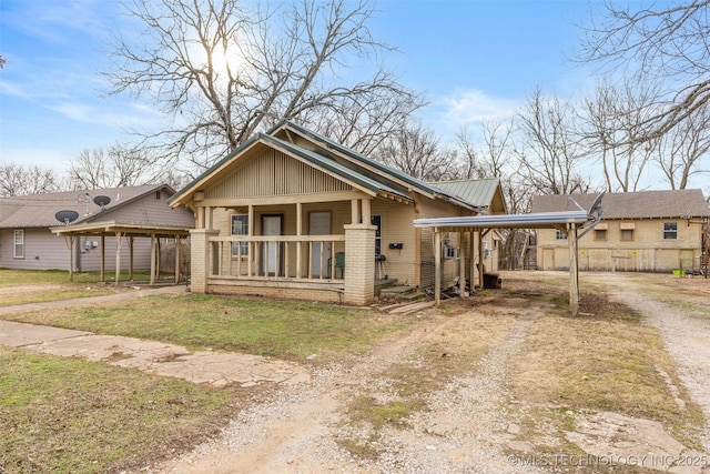 view of front of home with a front lawn, a carport, and a porch