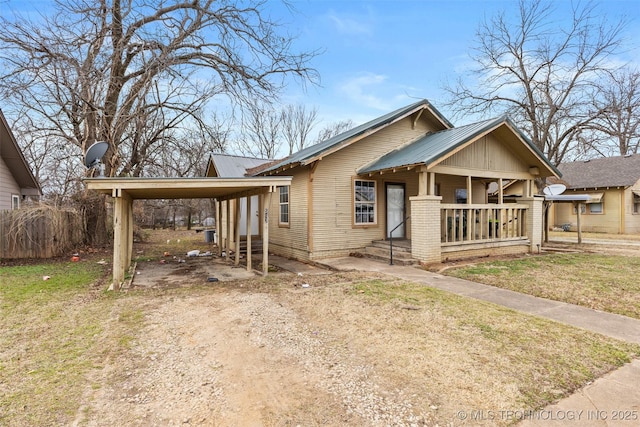 view of front of house featuring a carport, a porch, and a front lawn