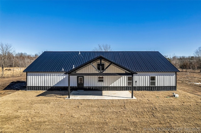 rear view of property featuring a patio area and a lawn