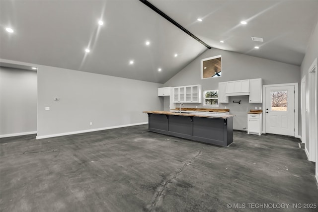 kitchen featuring sink, a center island, high vaulted ceiling, plenty of natural light, and white cabinets