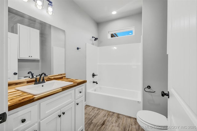 full bathroom with vanity, hardwood / wood-style floors, toilet, and washtub / shower combination