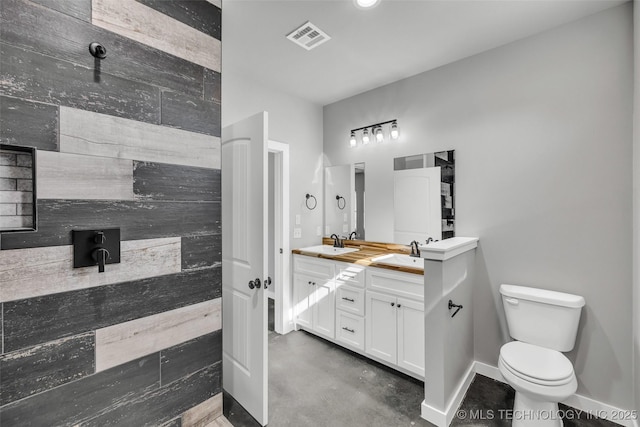 bathroom with vanity, concrete floors, and toilet