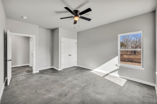 unfurnished bedroom with ceiling fan and a closet