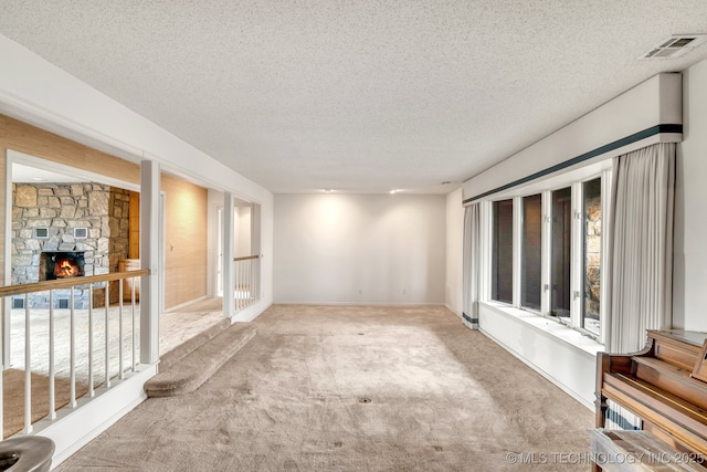 interior space with a fireplace, a textured ceiling, and carpet flooring