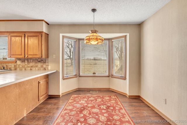 unfurnished dining area with dark hardwood / wood-style flooring and a textured ceiling