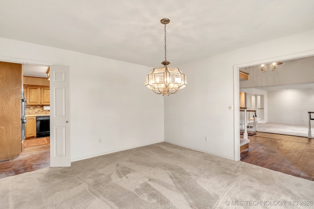 empty room featuring carpet flooring and a notable chandelier