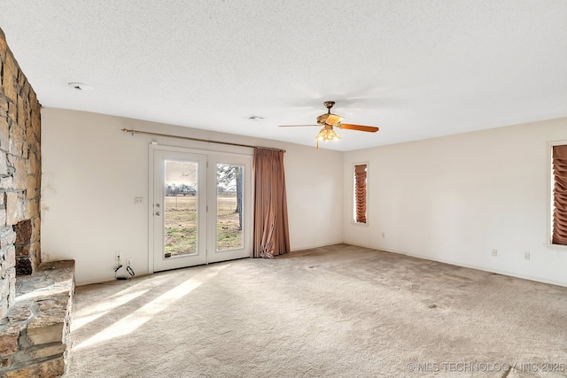 unfurnished living room with ceiling fan, light colored carpet, and a textured ceiling