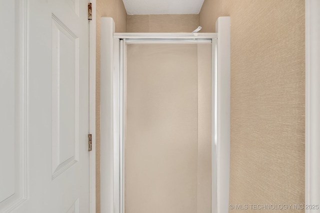 bathroom featuring a shower with door