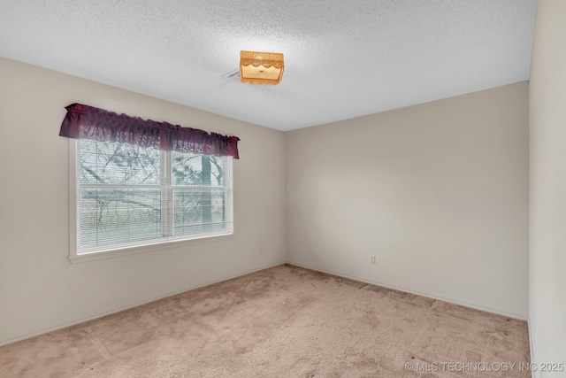 carpeted empty room featuring a textured ceiling