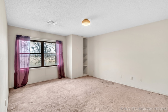 unfurnished room featuring carpet flooring and a textured ceiling