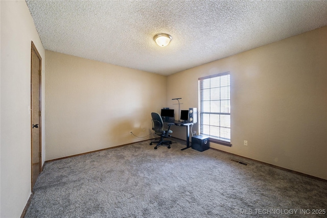 unfurnished office with carpet floors and a textured ceiling