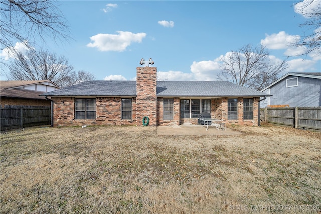 rear view of house featuring a yard and a patio