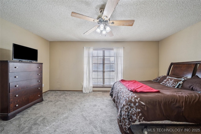 carpeted bedroom with ceiling fan and a textured ceiling