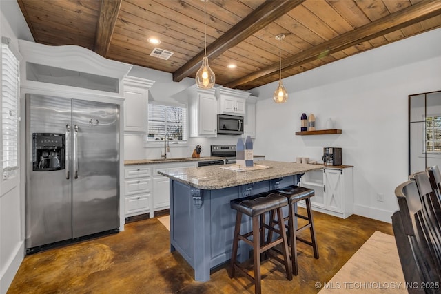 kitchen with a kitchen island, sink, white cabinets, stainless steel appliances, and light stone countertops