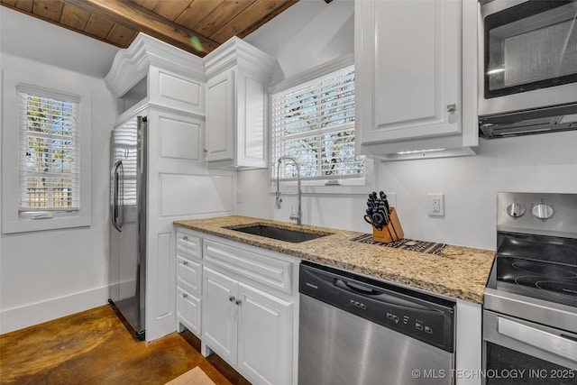 kitchen featuring white cabinetry, stainless steel appliances, light stone countertops, and sink