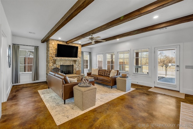 living room with beamed ceiling, ceiling fan, concrete flooring, and a stone fireplace