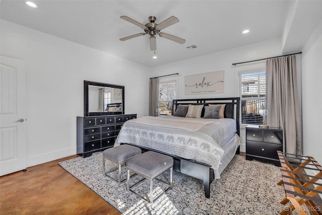 bedroom with multiple windows, concrete flooring, and ceiling fan