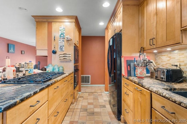 kitchen with backsplash, dark stone counters, and black appliances