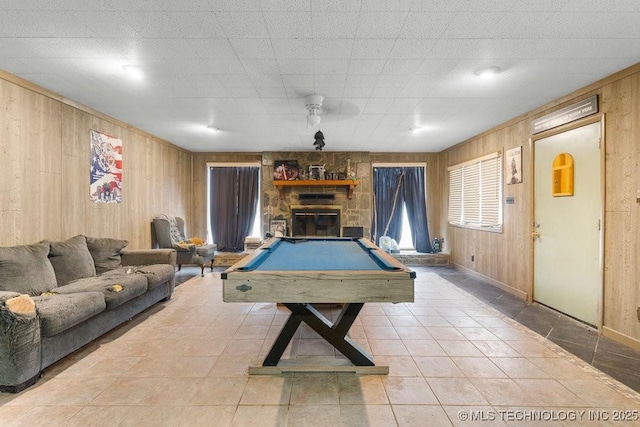 playroom featuring a stone fireplace, wood walls, and billiards