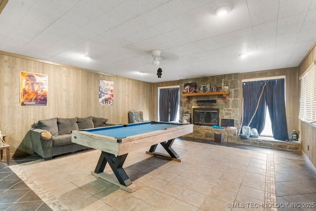 game room featuring pool table, light tile patterned floors, wooden walls, ceiling fan, and a fireplace