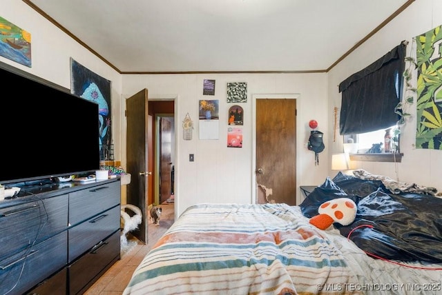 bedroom with ornamental molding and light wood-type flooring