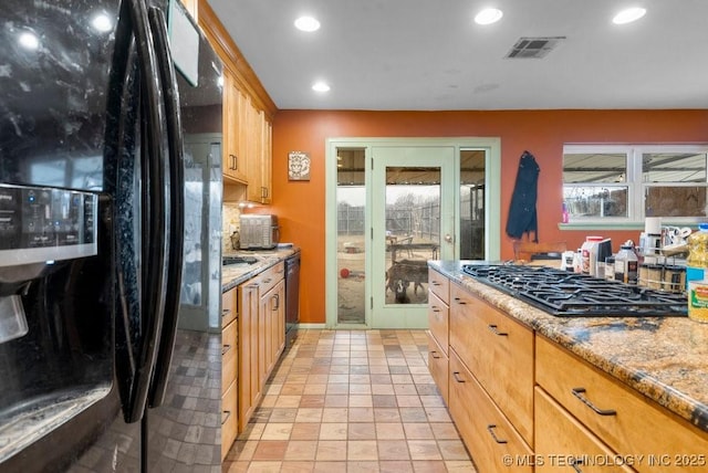 kitchen featuring light stone counters, tasteful backsplash, and black appliances