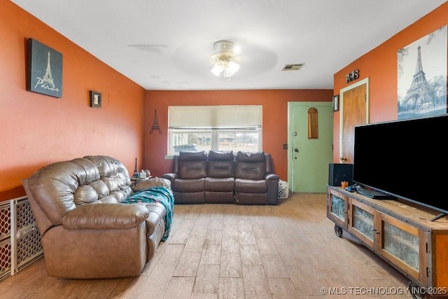 living room featuring ceiling fan and light hardwood / wood-style flooring