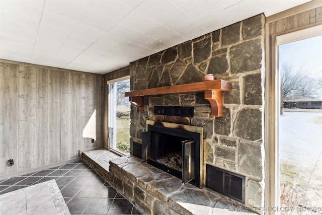 living area featuring tile patterned floors, wooden walls, and a fireplace