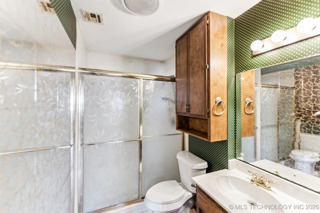 bathroom with vanity, visible vents, a stall shower, tile walls, and toilet