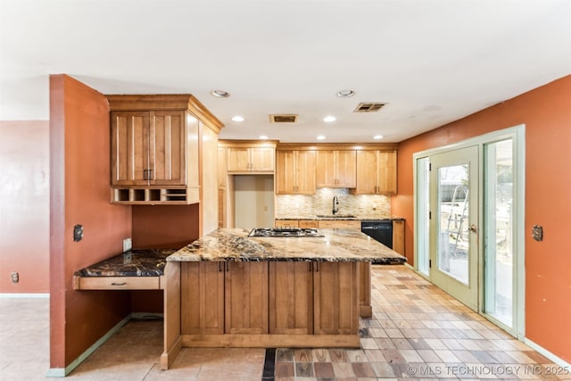 kitchen with a sink, visible vents, stone countertops, and tasteful backsplash