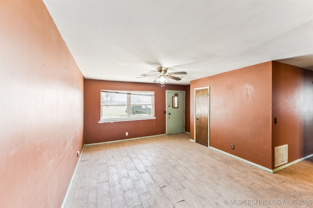 unfurnished room featuring ceiling fan, visible vents, baseboards, and light wood-style flooring