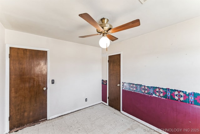 empty room featuring light floors, baseboards, and a ceiling fan