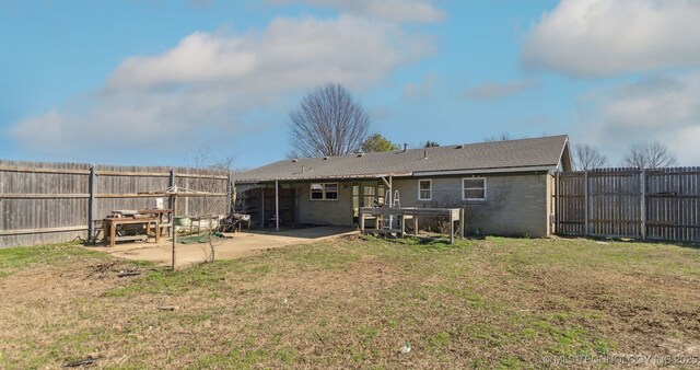 back of property featuring a fenced backyard, a yard, and a patio