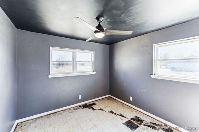 spare room with tile patterned floors, baseboards, and a ceiling fan